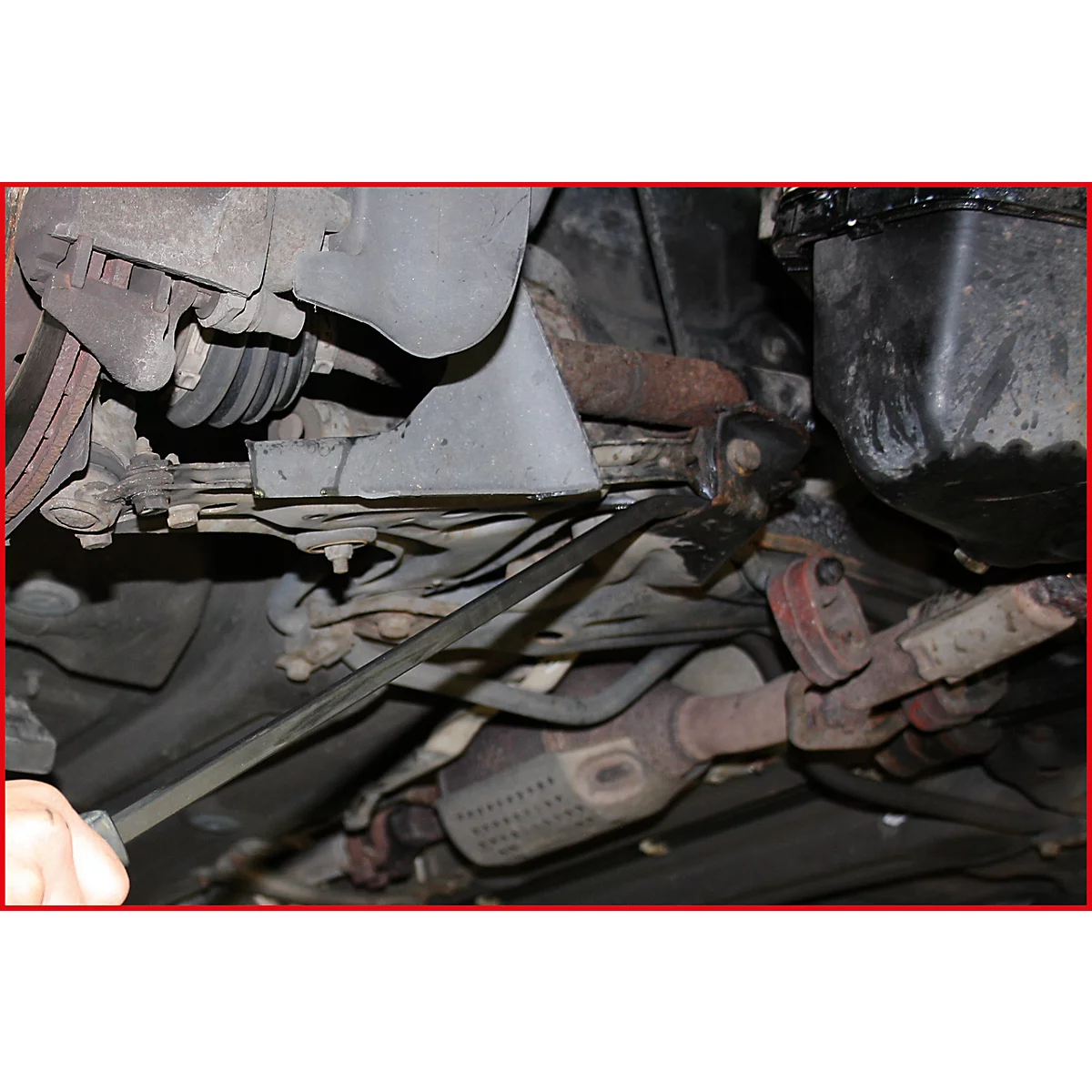 Blick von unten auf ein Auto. Der Auspuff und weitere Fahrzeugteile sind zu sehen.